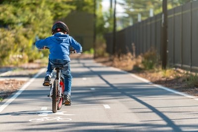 A young child riding a bike in a bike lane.