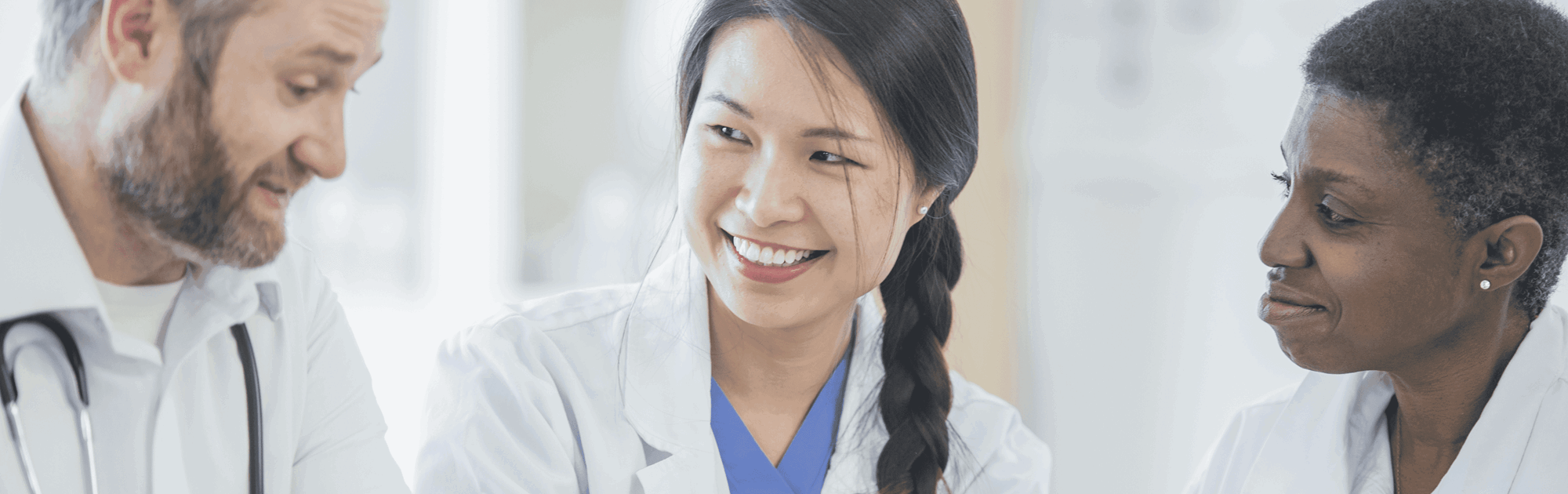 3 smiling medical colleagues in a meeting