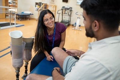 Staff member works with a patient in a physio gym.